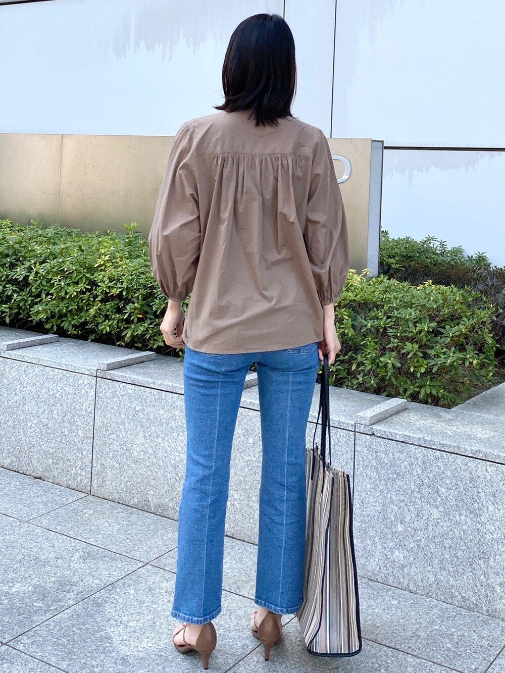 ベージュ系のシャツ/ブラウス、ブラック系のトートバッグ、ブラウン系のサンダルを着用したレディースの春コーディネートの2枚目の写真