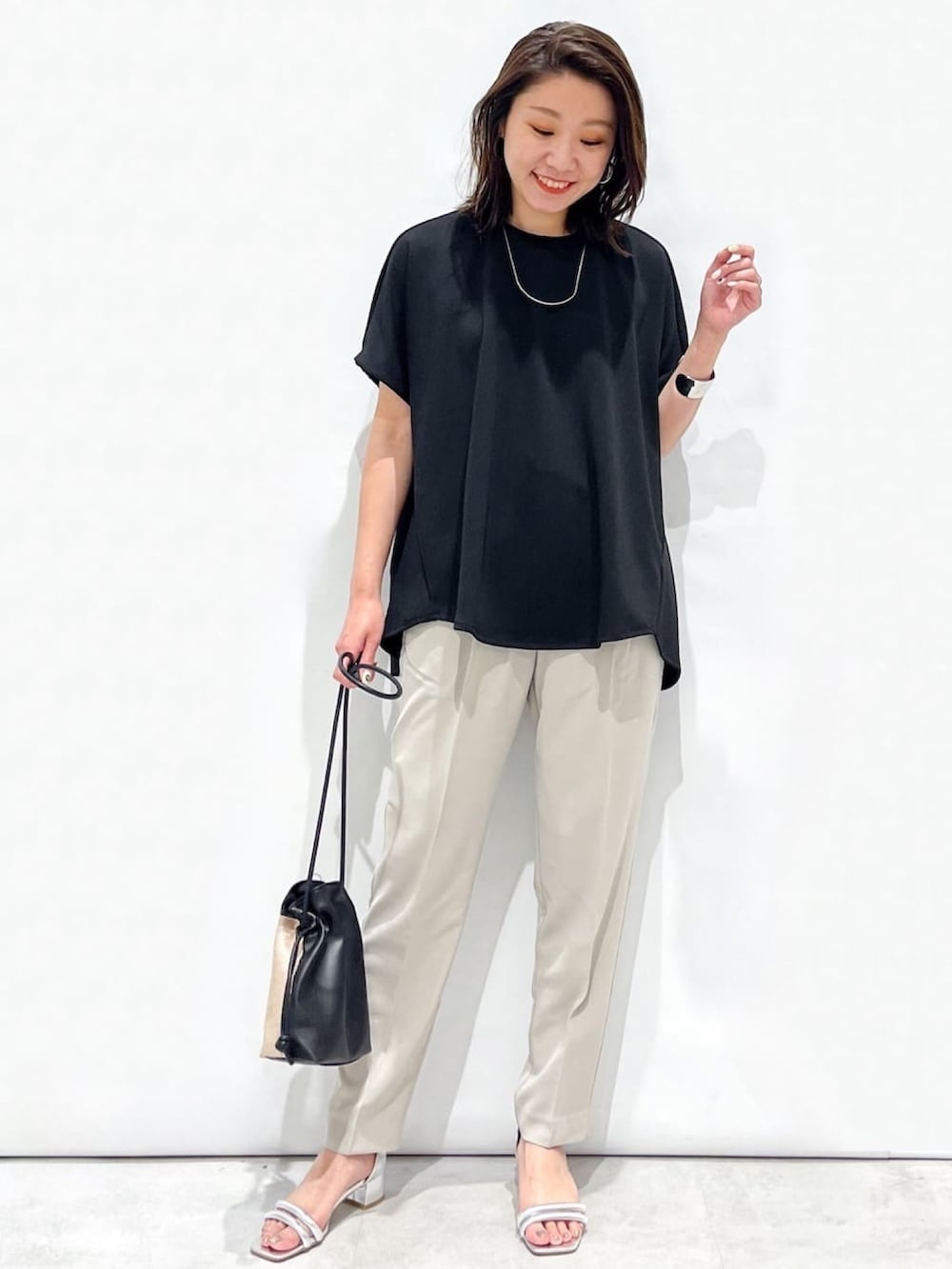 ブラック系のTシャツ/カットソー、グレー系のその他パンツ、シルバー系のサンダルを着用したレディースの春コーディネートの4枚目の写真