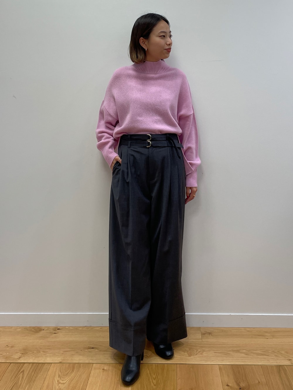 ブラック系のトレンチコート、ピンク系のニット/セーター、ブラック系のブーツを着用したレディースの秋コーディネートの4枚目の写真