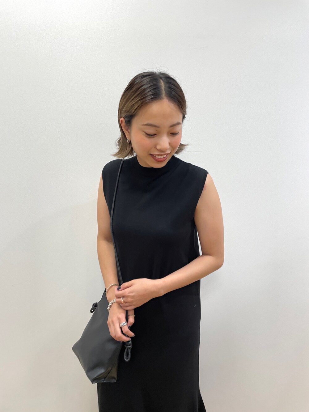 ブラック系のワンピース、ブラック系のショルダーバッグ、ブラック系のサンダルを着用したレディースの夏コーディネートの4枚目の写真