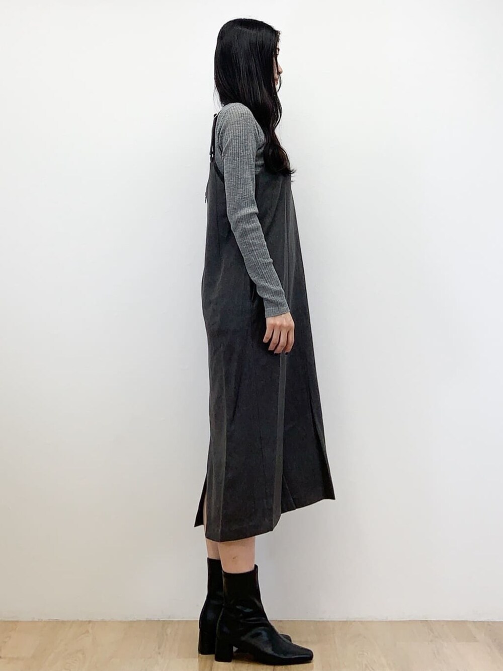 グレー系のワンピース、グレー系のニット/セーター、ブラック系のブーツを着用したレディースの秋コーディネートの2枚目の写真