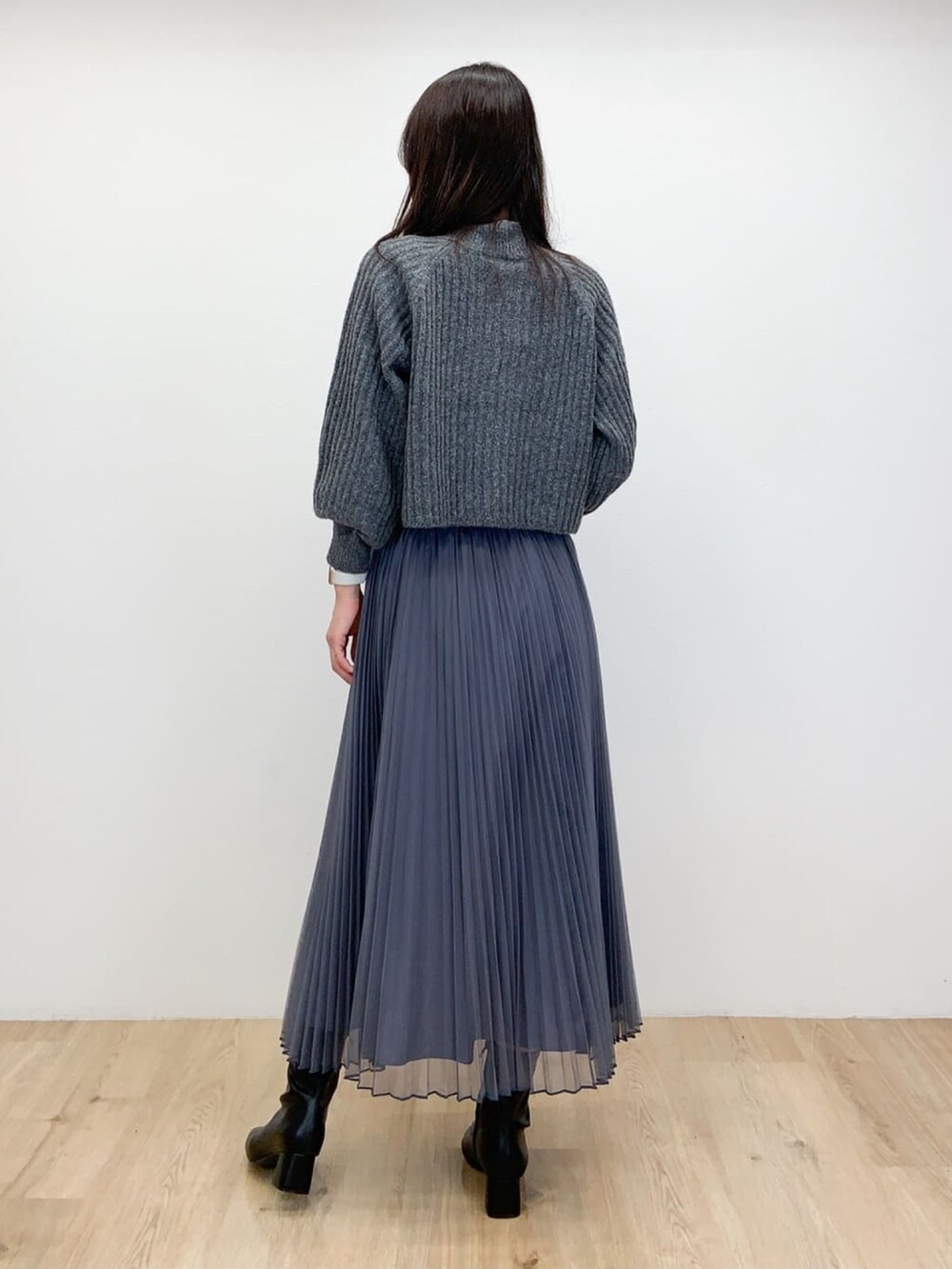 グレー系のニット/セーター、ブラック系のブーツ、グレー系のスカートを着用したレディースの冬コーディネートの3枚目の写真