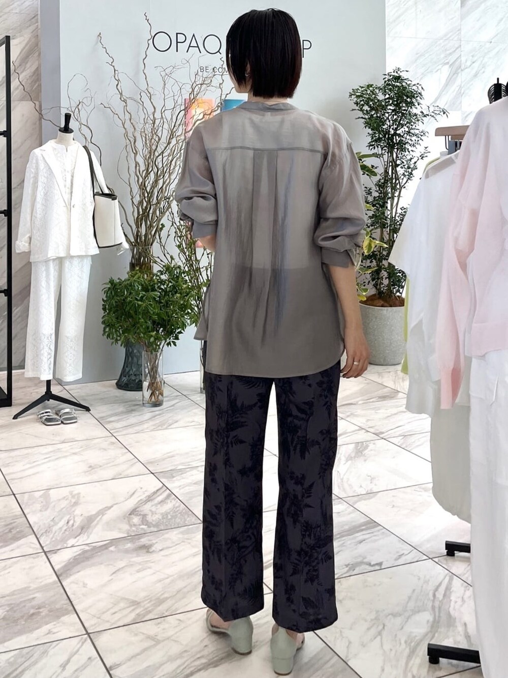 グレー系のその他パンツ、グリーン系のサンダル、グレー系のシャツ/ブラウスを着用したレディースの春コーディネートの5枚目の写真