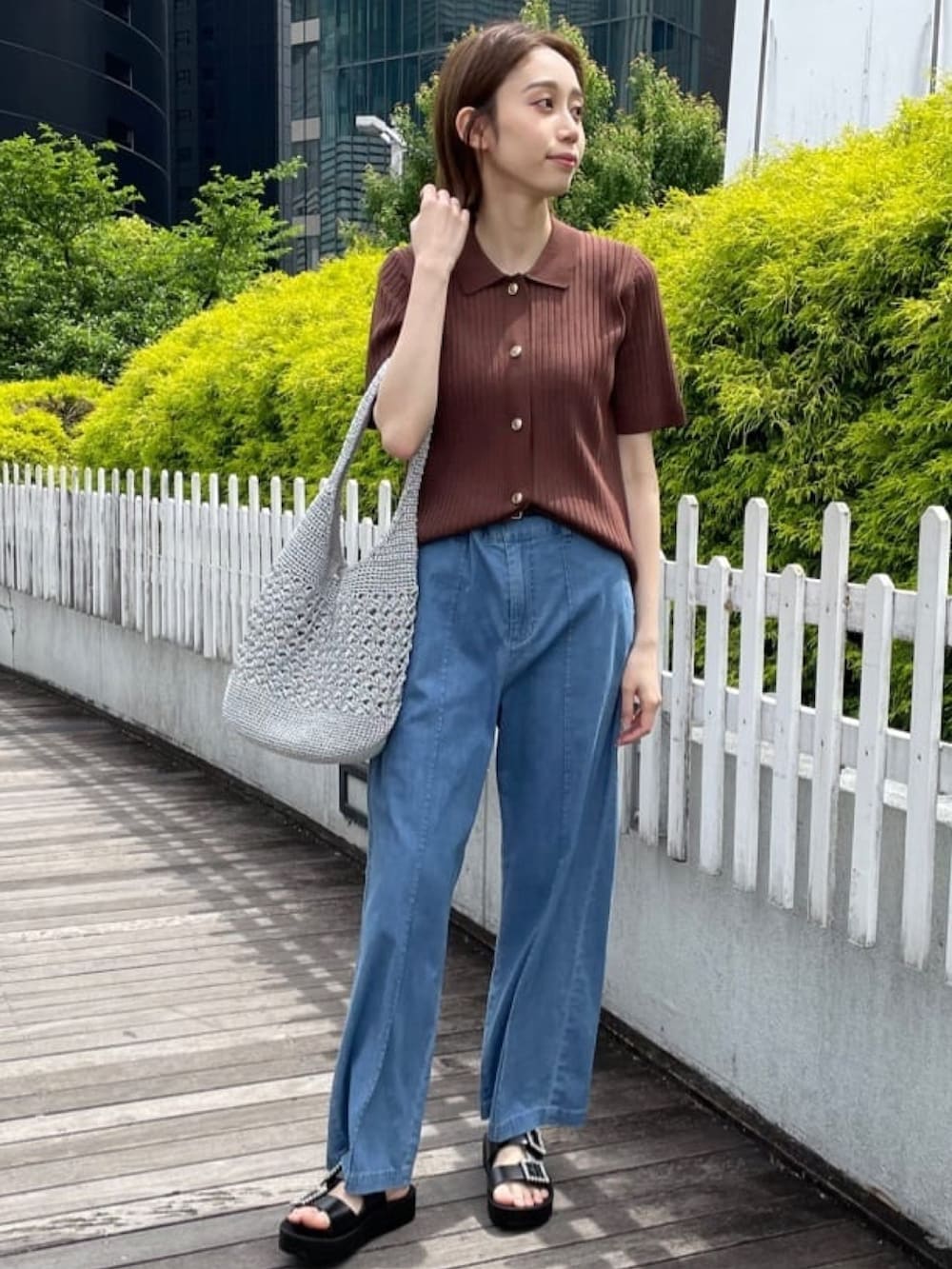 ブラウン系のニット/セーター、ブルー系のデニムパンツ、シルバー系のトートバッグを着用したレディースの春コーディネートの2枚目の写真