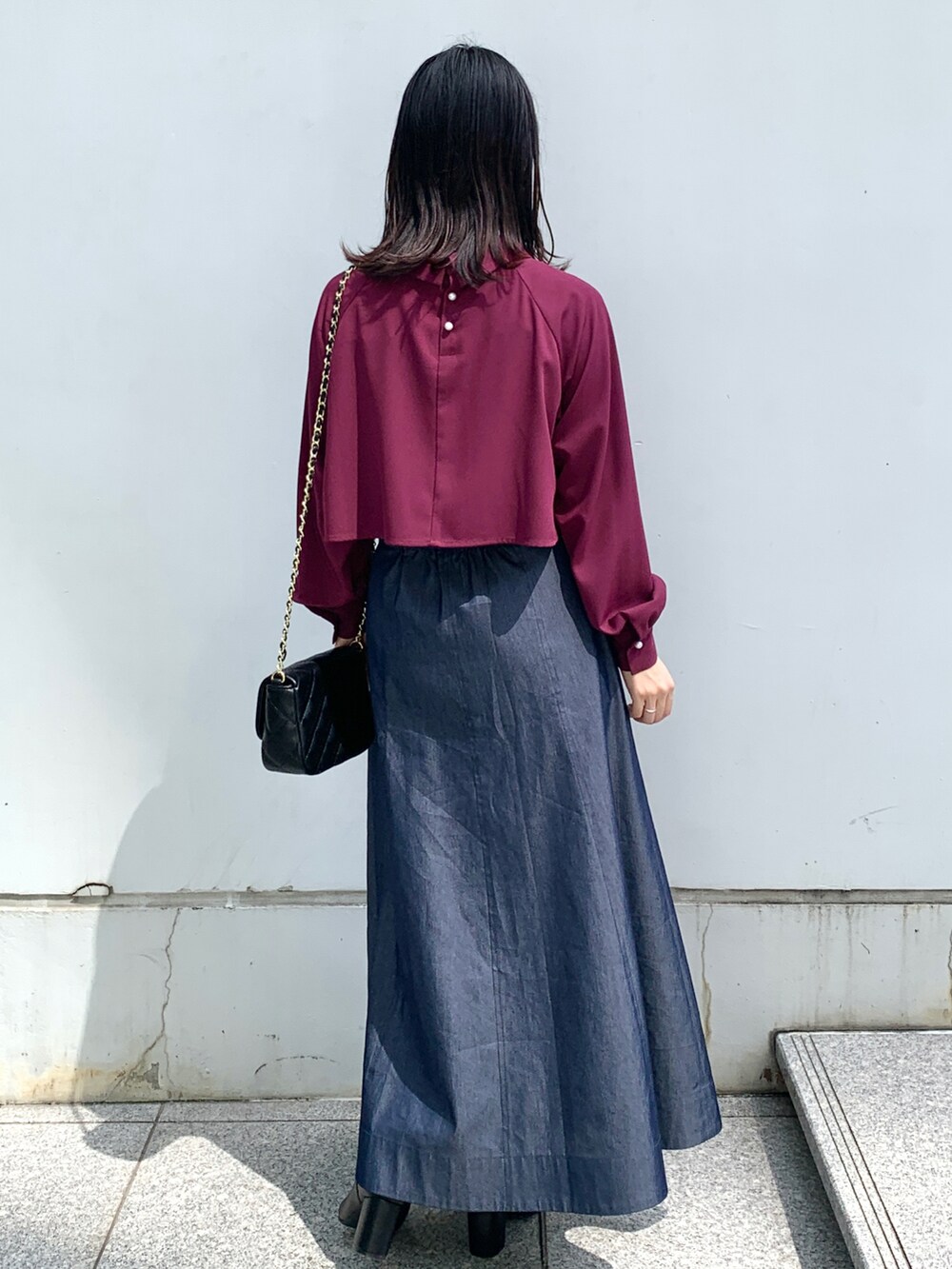 パープル系のシャツ/ブラウス、ブルー系のスカート、ブラック系のショルダーバッグを着用したレディースの秋コーディネートの2枚目の写真