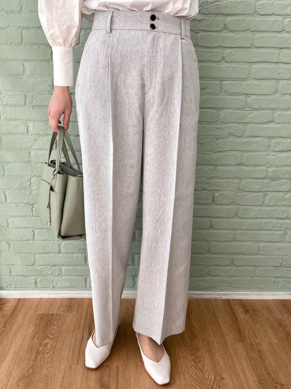 グリーン系のトートバッグ、ホワイト系のシャツ/ブラウス、ホワイト系のトレンチコートを着用したレディースの春コーディネートの4枚目の写真