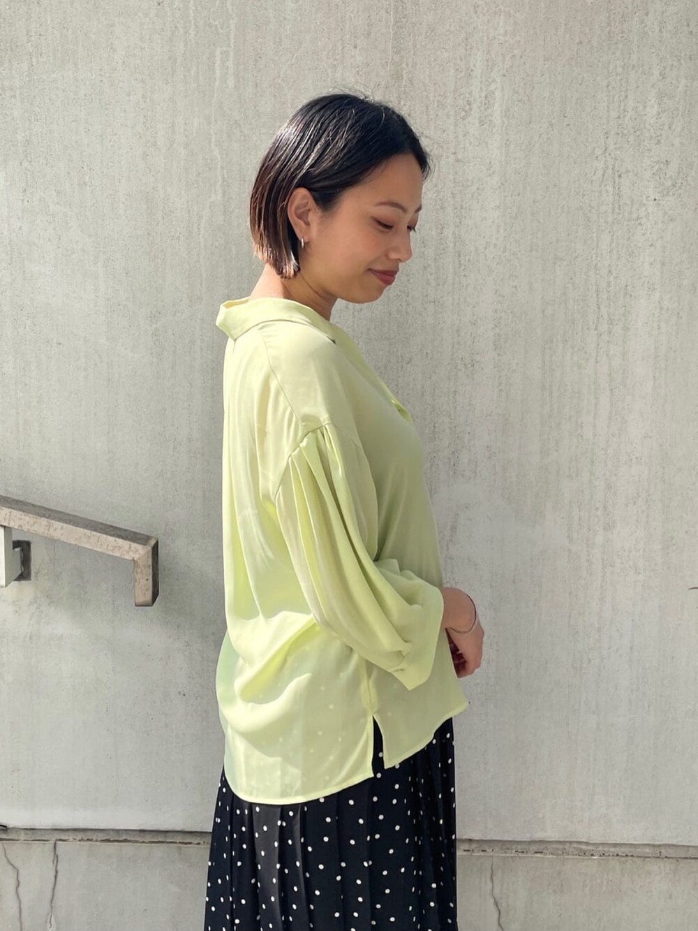 グリーン系のシャツ/ブラウス、ブラック系のスカート、ブラック系のサンダルを着用したレディースの春コーディネートの4枚目の写真