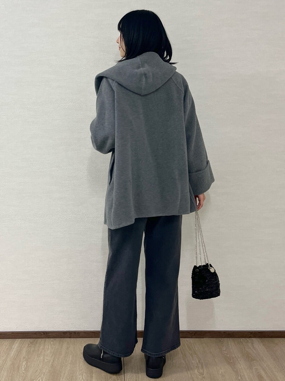 ホワイト系のニット/セーター、グレー系のその他アウター、ブラック系のショルダーバッグを着用したレディースの冬コーディネートの4枚目の写真