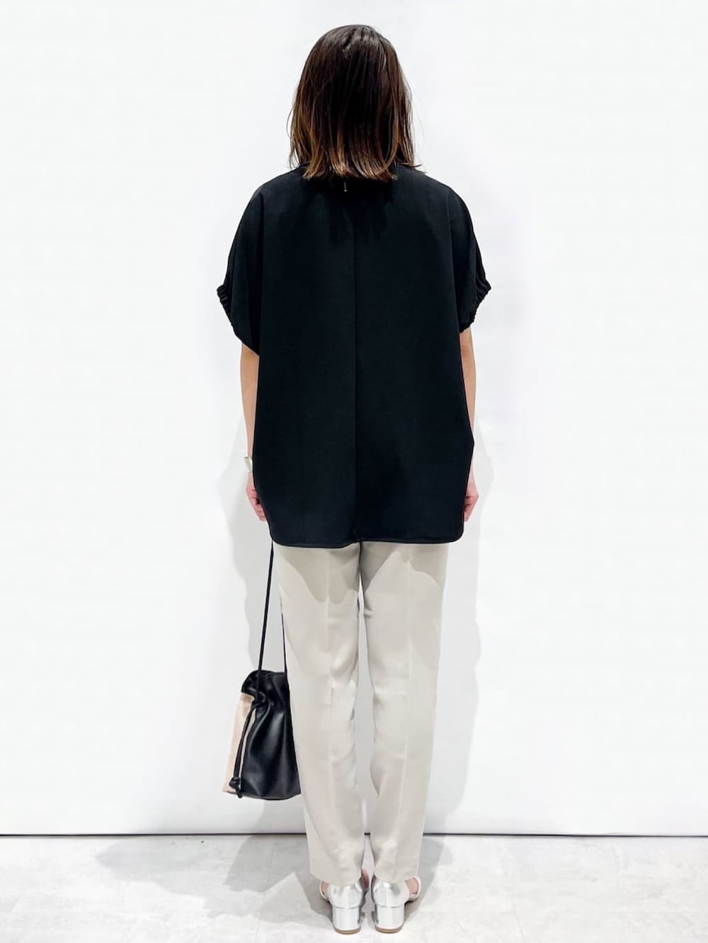 ブラック系のTシャツ/カットソー、グレー系のその他パンツ、シルバー系のサンダルを着用したレディースの春コーディネートの7枚目の写真