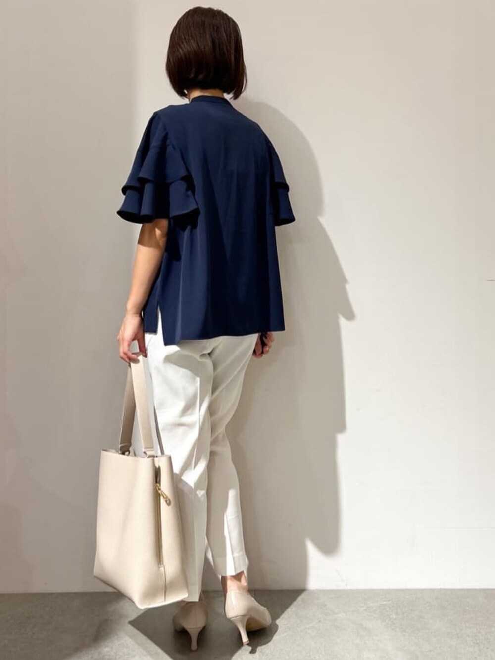 ブルー系のシャツ/ブラウス、ホワイト系のその他パンツ、ベージュ系のショルダーバッグを着用したレディースの夏コーディネートの4枚目の写真