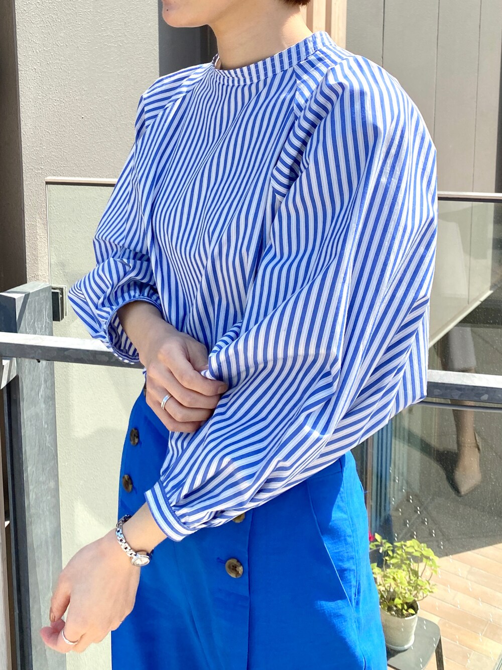 ブルー系のシャツ/ブラウス、ブルー系のその他パンツ、ホワイト系のサンダルを着用したレディースの春コーディネートの2枚目の写真