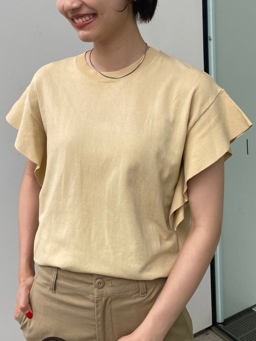 ベージュ系のその他パンツ、ブラウン系のショルダーバッグ、イエロー系のニット/セーターを着用したレディースの夏コーディネートの4枚目の写真