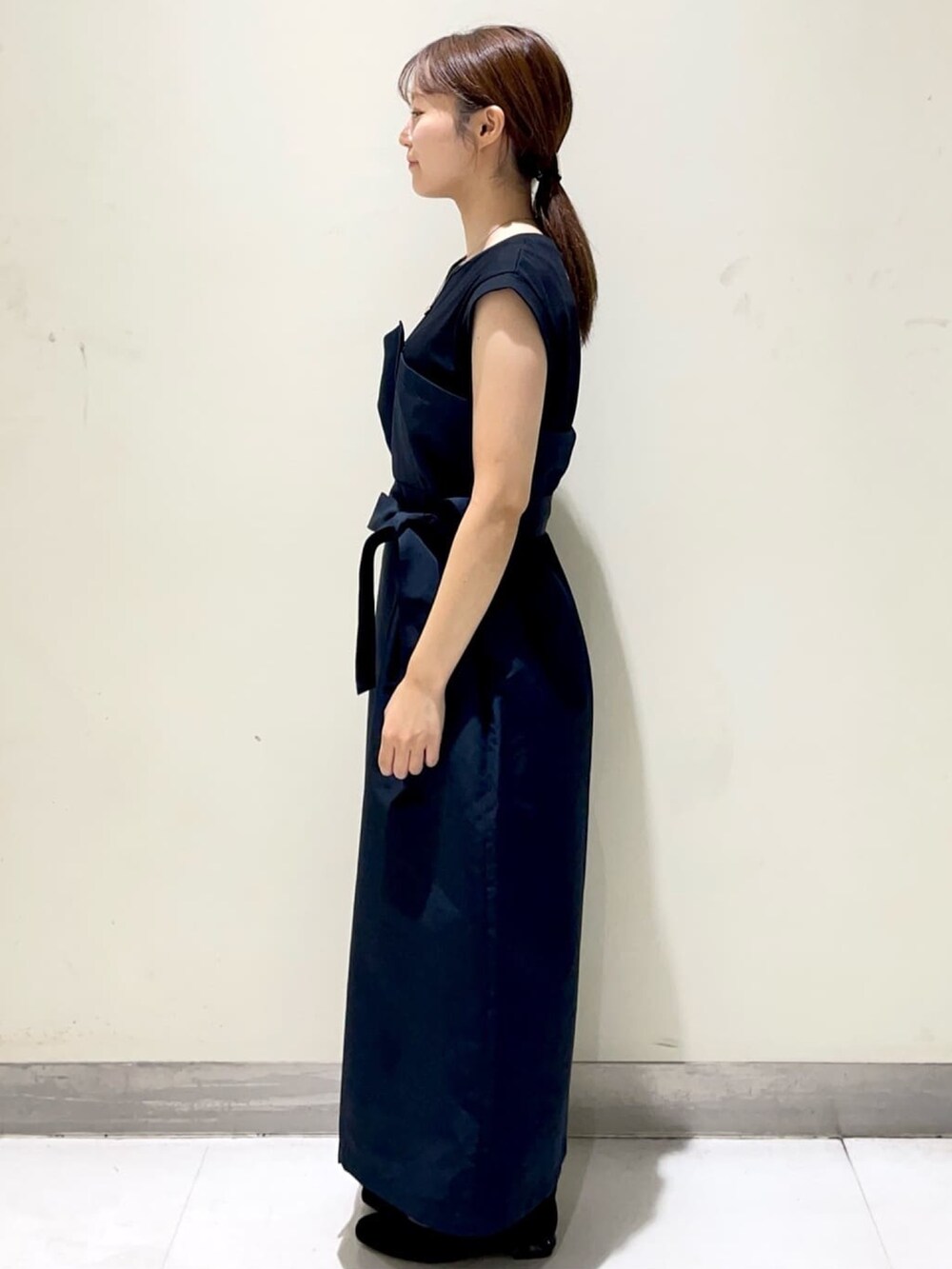 ブルー系のワンピース、ブラック系のパンプス、ブラック系のショルダーバッグを着用したレディースの秋コーディネートの4枚目の写真