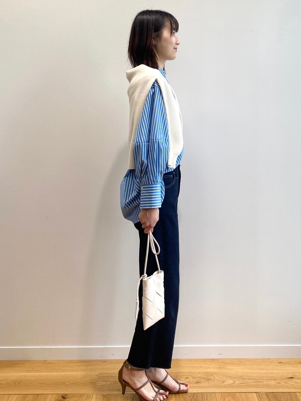 ブラウン系のサンダル、ブルー系のシャツ/ブラウス、ホワイト系のニット/セーターを着用したレディースの春コーディネートの2枚目の写真