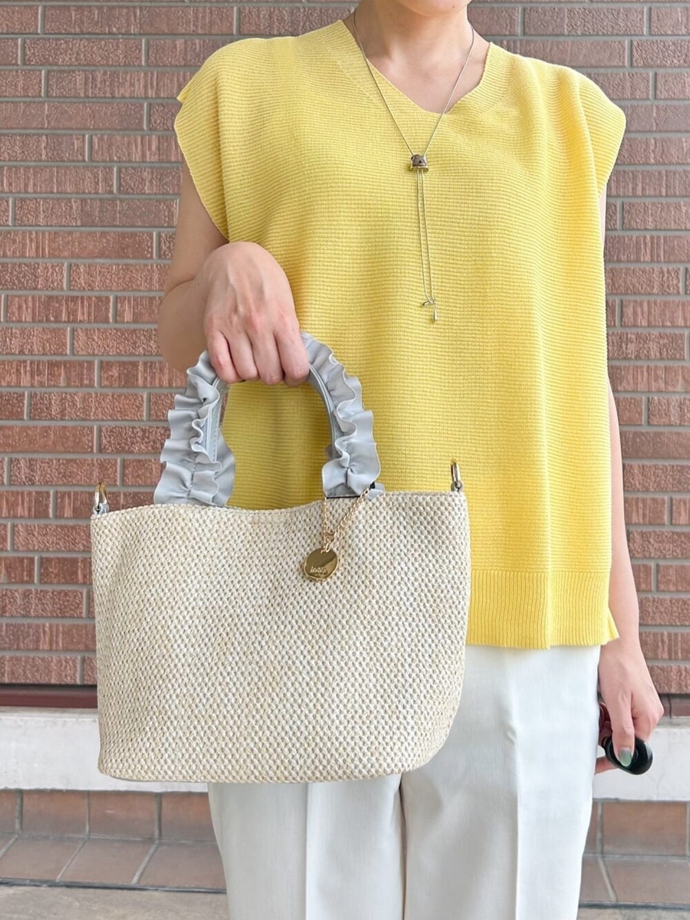 ホワイト系のその他パンツ、グレー系のトートバッグ、シルバー系のサンダルを着用したレディースの春コーディネートの5枚目の写真