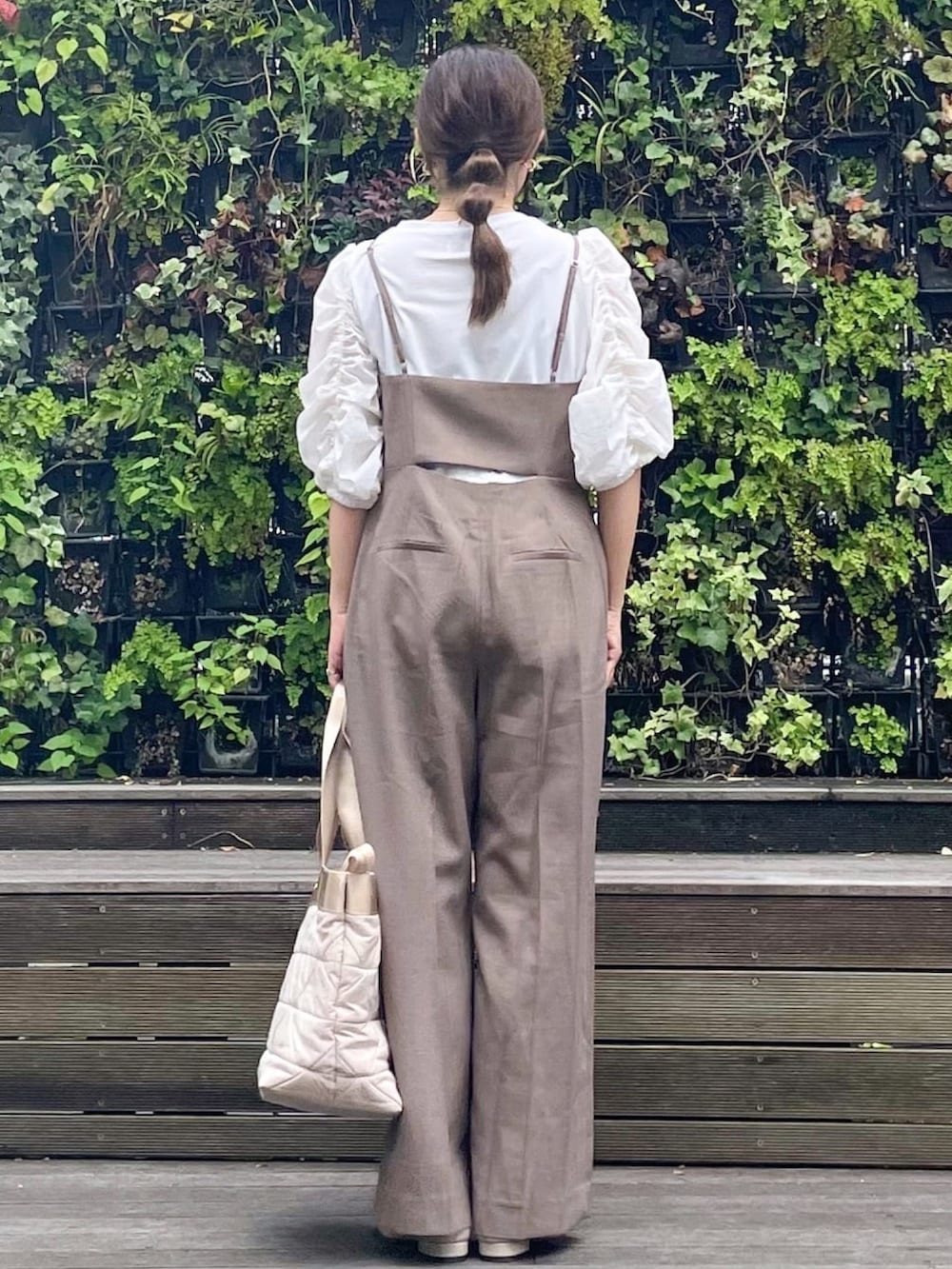 ベージュ系のトートバッグ、ベージュ系のドレスシューズ、ブラウン系のサロペット/オーバーオールを着用したレディースの秋コーディネートの4枚目の写真