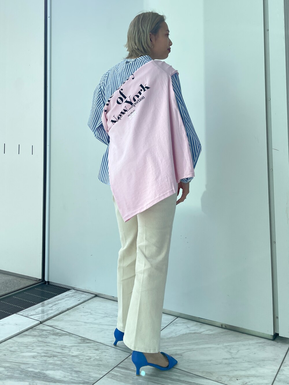 ブルー系のシャツ/ブラウス、ホワイト系のデニムパンツ、ブルー系のサンダルを着用したレディースの春コーディネートの2枚目の写真