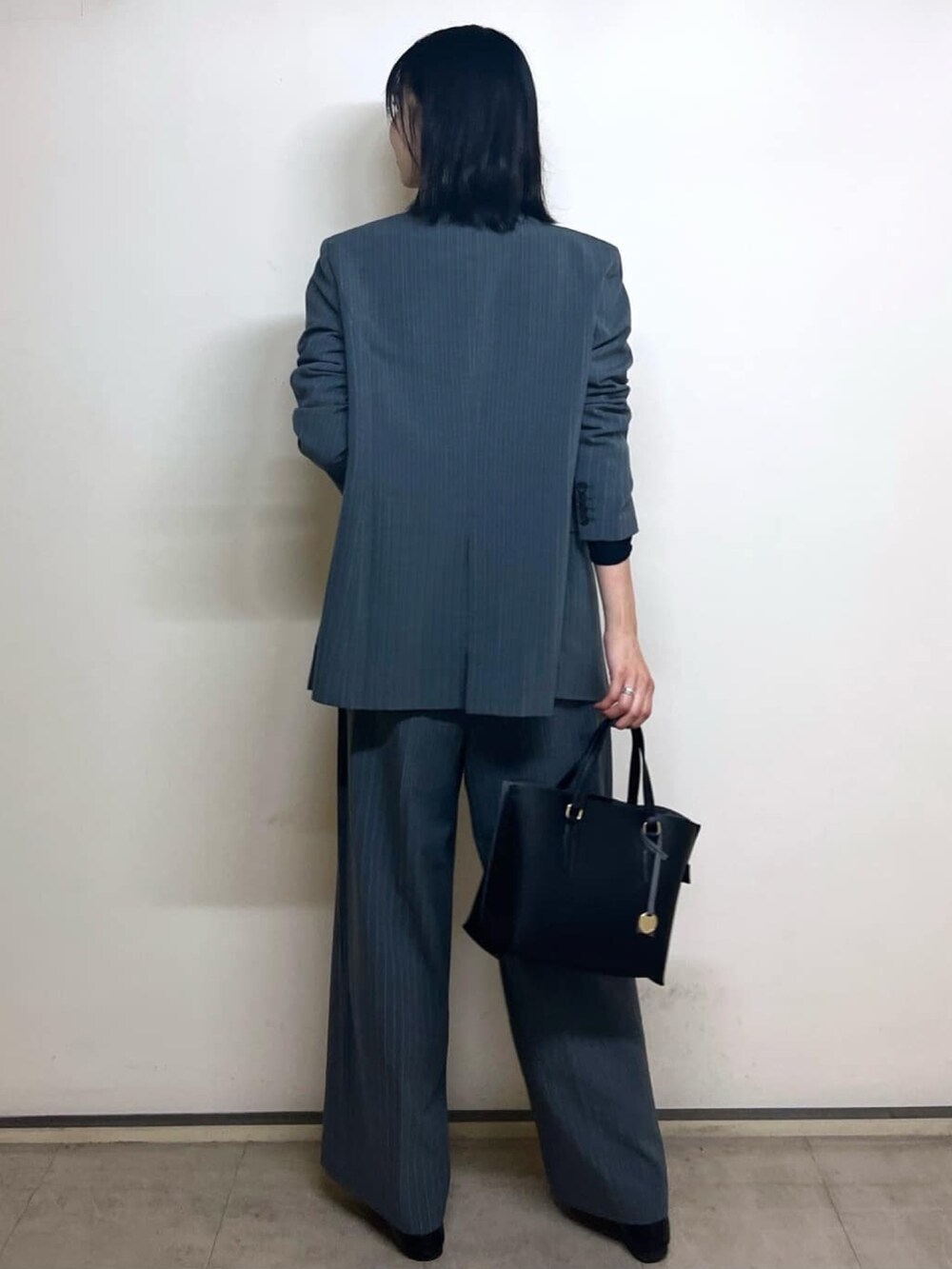 グレー系のテーラードジャケット、ブラック系のTシャツ/カットソー、ブラック系のトートバッグを着用したレディースの秋コーディネートの4枚目の写真