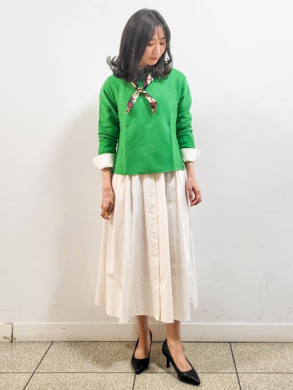 ホワイト系のワンピース、ブラック系のパンプス、ベージュ系のブルゾンを着用したレディースの春コーディネートの3枚目の写真