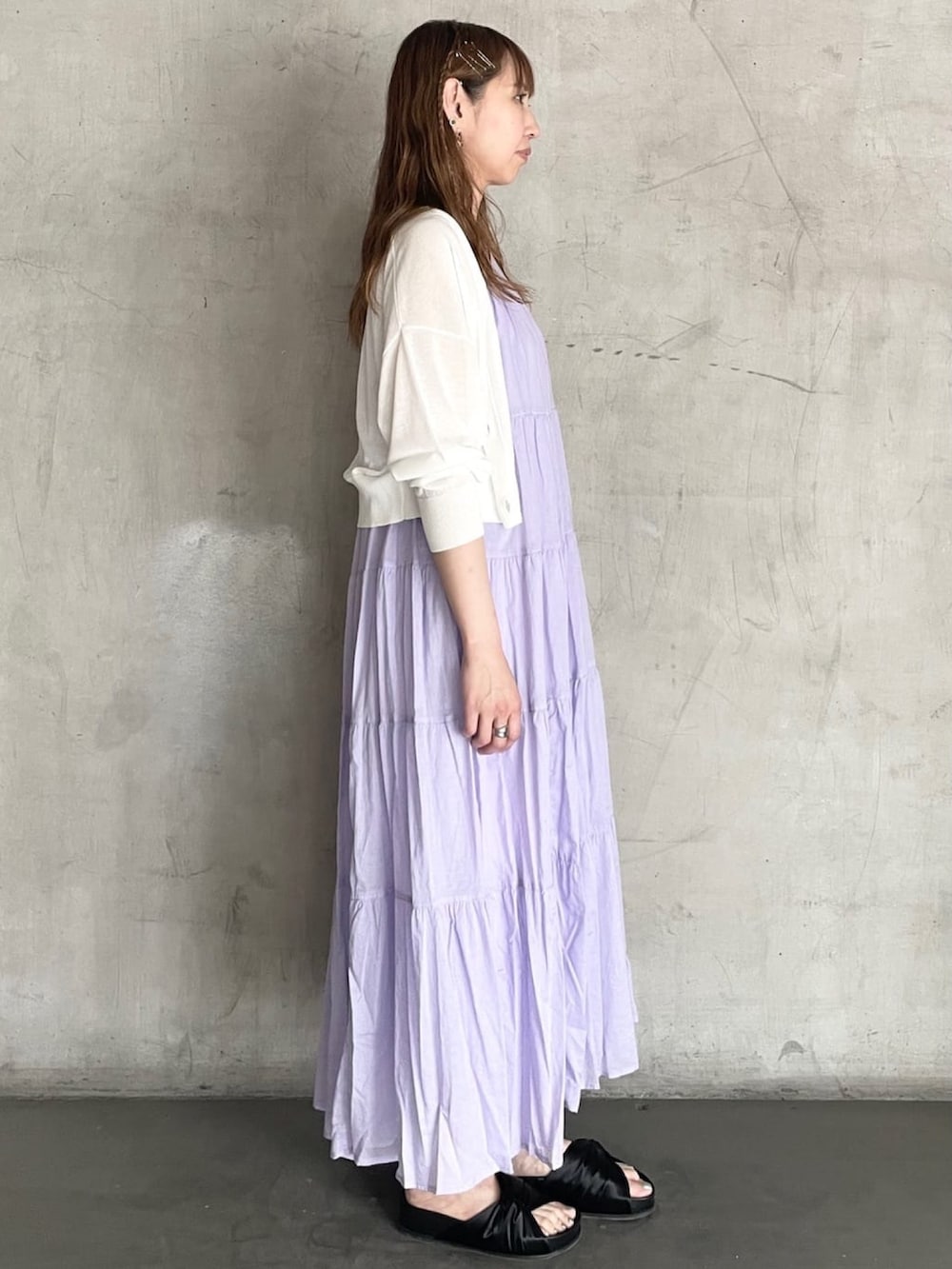 パープル系のワンピース、ホワイト系のカーディガン/ボレロ、ブラック系のサンダルを着用したレディースの春コーディネートの2枚目の写真