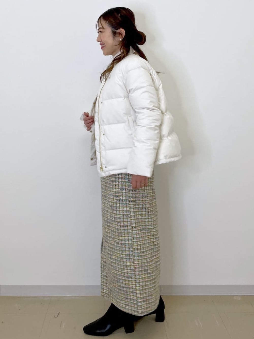 グリーン系のスカート、ホワイト系のダウンジャケット/コート、ホワイト系のニット/セーターを着用したレディースの冬コーディネートの4枚目の写真