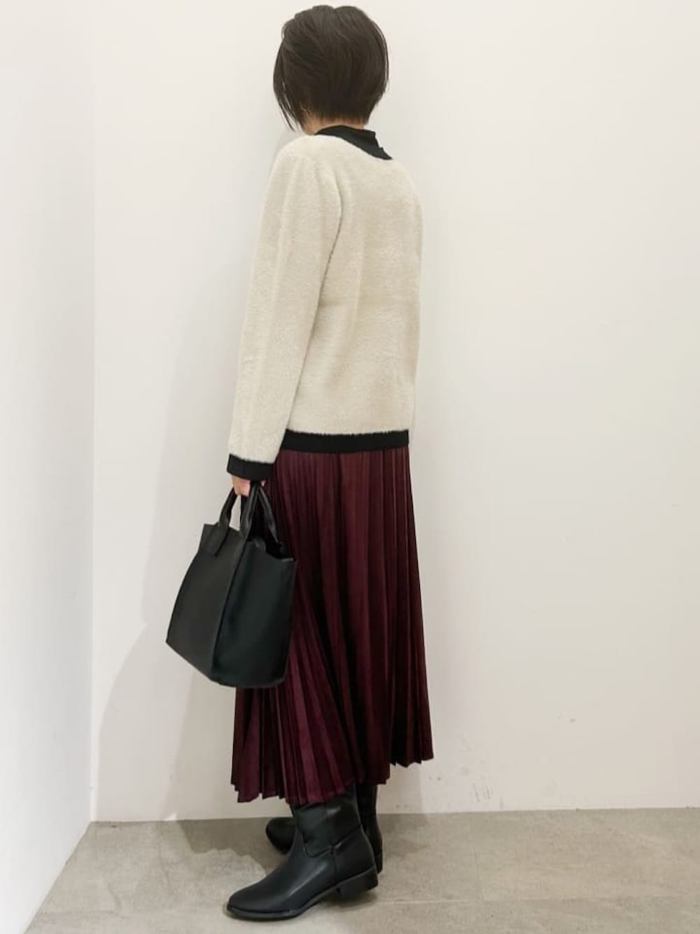 ベージュ系のカーディガン/ボレロ、ブラック系のTシャツ/カットソー、ブラック系のブーツを着用したレディースの秋コーディネートの2枚目の写真