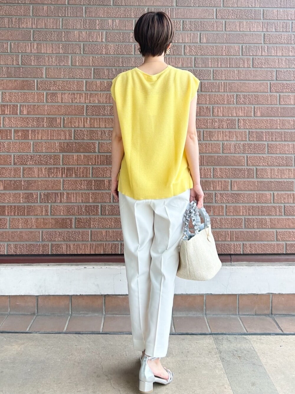 ホワイト系のその他パンツ、グレー系のトートバッグ、シルバー系のサンダルを着用したレディースの春コーディネートの4枚目の写真