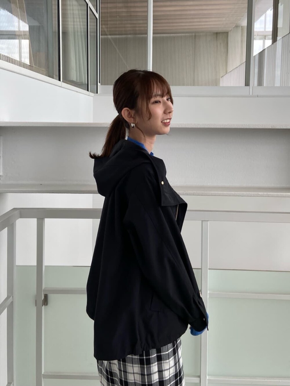 ブラック系のブルゾン、ブルー系のニット/セーター、ブラック系のスカートを着用したレディースの夏コーディネートの7枚目の写真