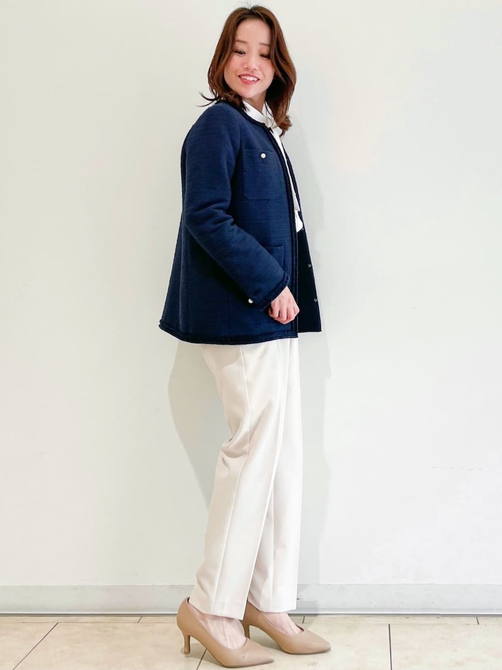 ブルー系のノーカラージャケット、ブラック系のパンプス、ベージュ系のその他パンツを着用したレディースの春コーディネートの2枚目の写真