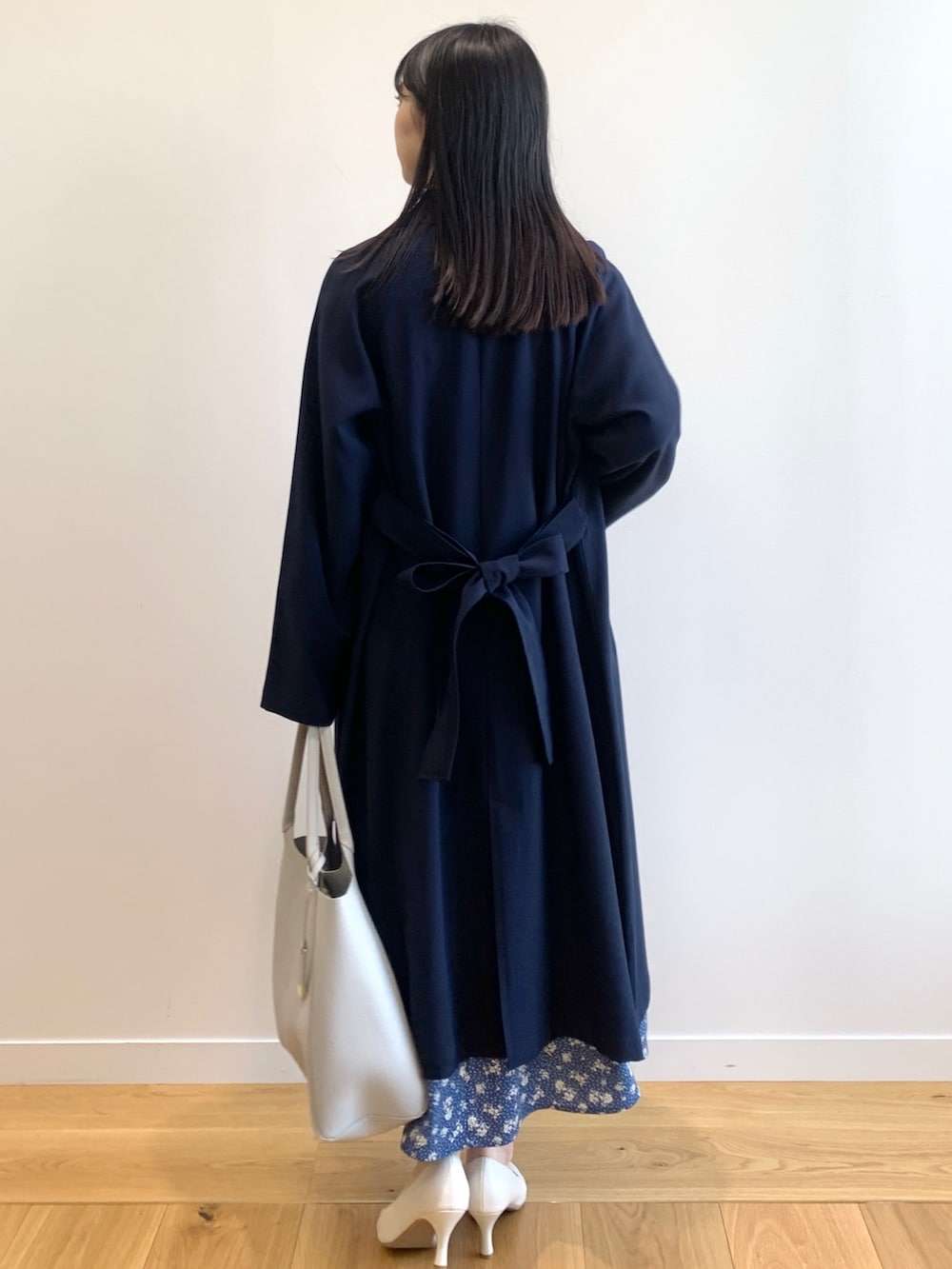 ブルー系のトレンチコート、ブルー系のワンピース、グレー系のトートバッグを着用したレディースの春コーディネートの3枚目の写真