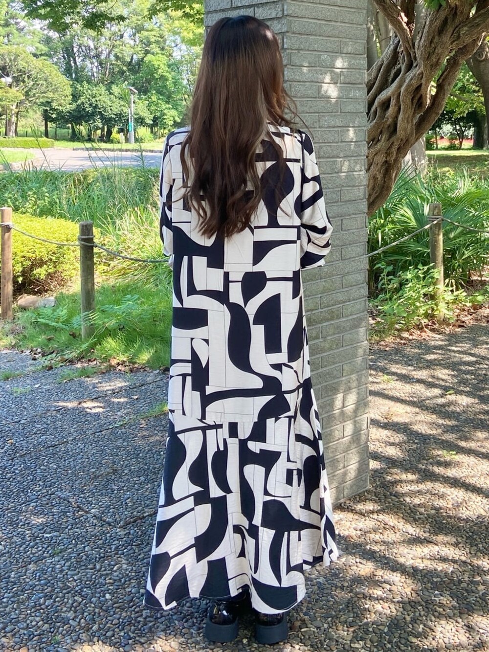 ベージュ系のワンピース、ブラック系のショルダーバッグを着用したレディースの秋コーディネートの4枚目の写真