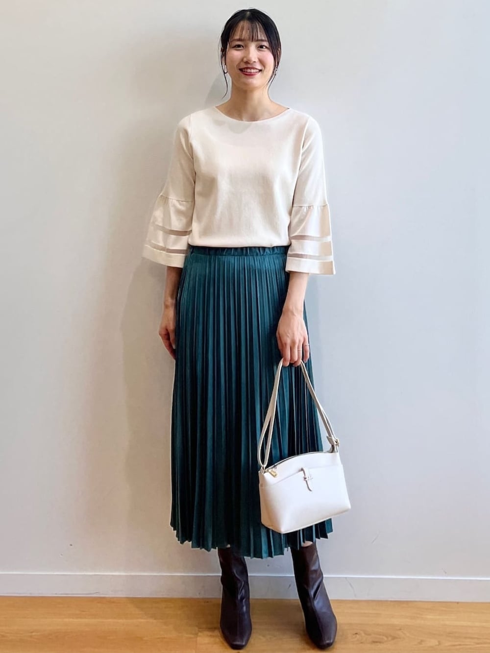ブラウン系のブーツ、ホワイト系のニット/セーター、ブルー系のスカートを着用したレディースの夏コーディネートの8枚目の写真
