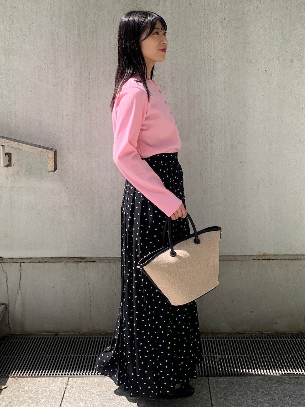 ピンク系のカーディガン/ボレロ、ブラック系のトートバッグ、ブラック系のスカートを着用したレディースの春コーディネートの2枚目の写真