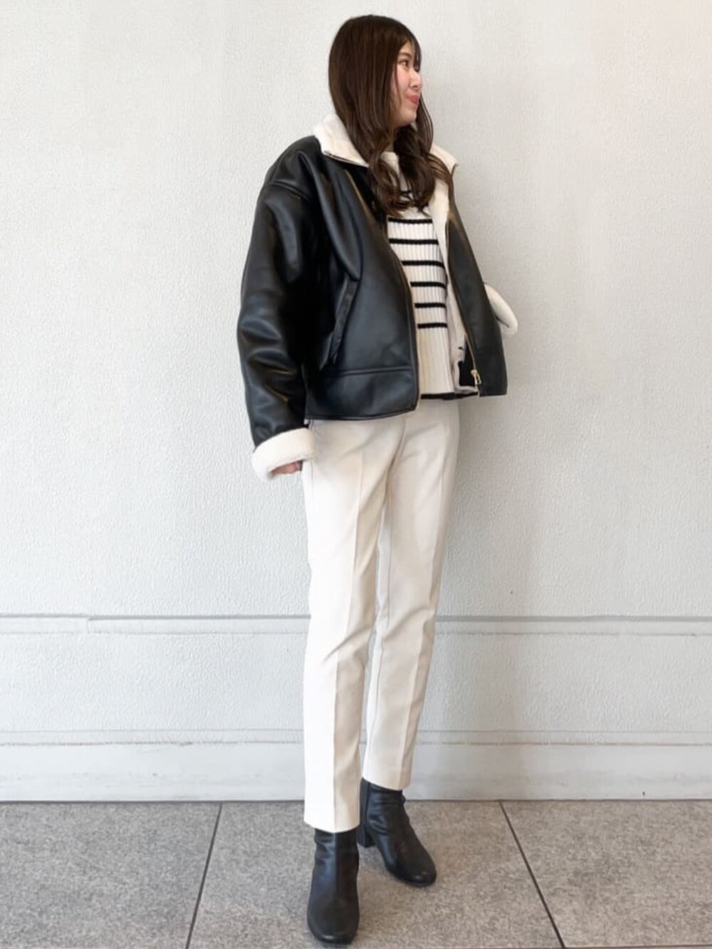 ブラック系のブルゾン、ホワイト系のその他パンツ、ホワイト系のニット/セーターを着用したレディースの冬コーディネートの3枚目の写真