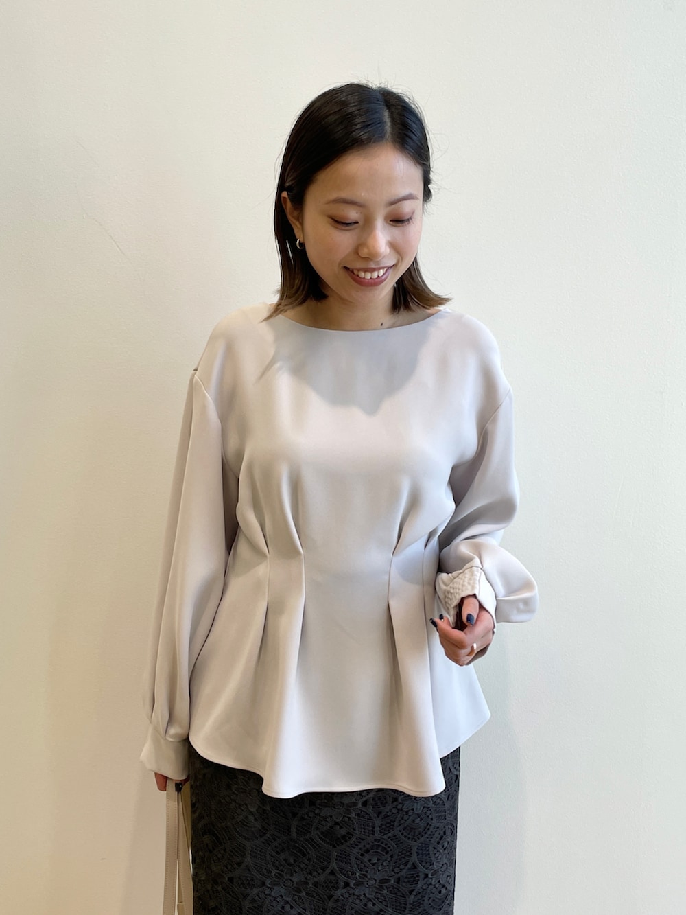 グレー系のシャツ/ブラウス、グレー系のスカート、ベージュ系のトートバッグを着用したレディースの冬コーディネートの4枚目の写真