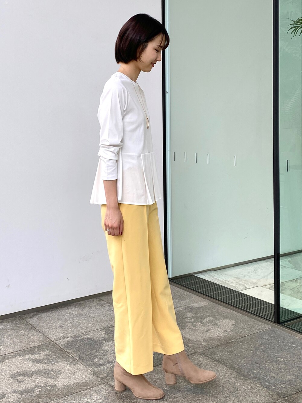 ホワイト系のTシャツ/カットソー、イエロー系のその他パンツ、ゴールド系のネックレスを着用したレディースの秋コーディネートの2枚目の写真
