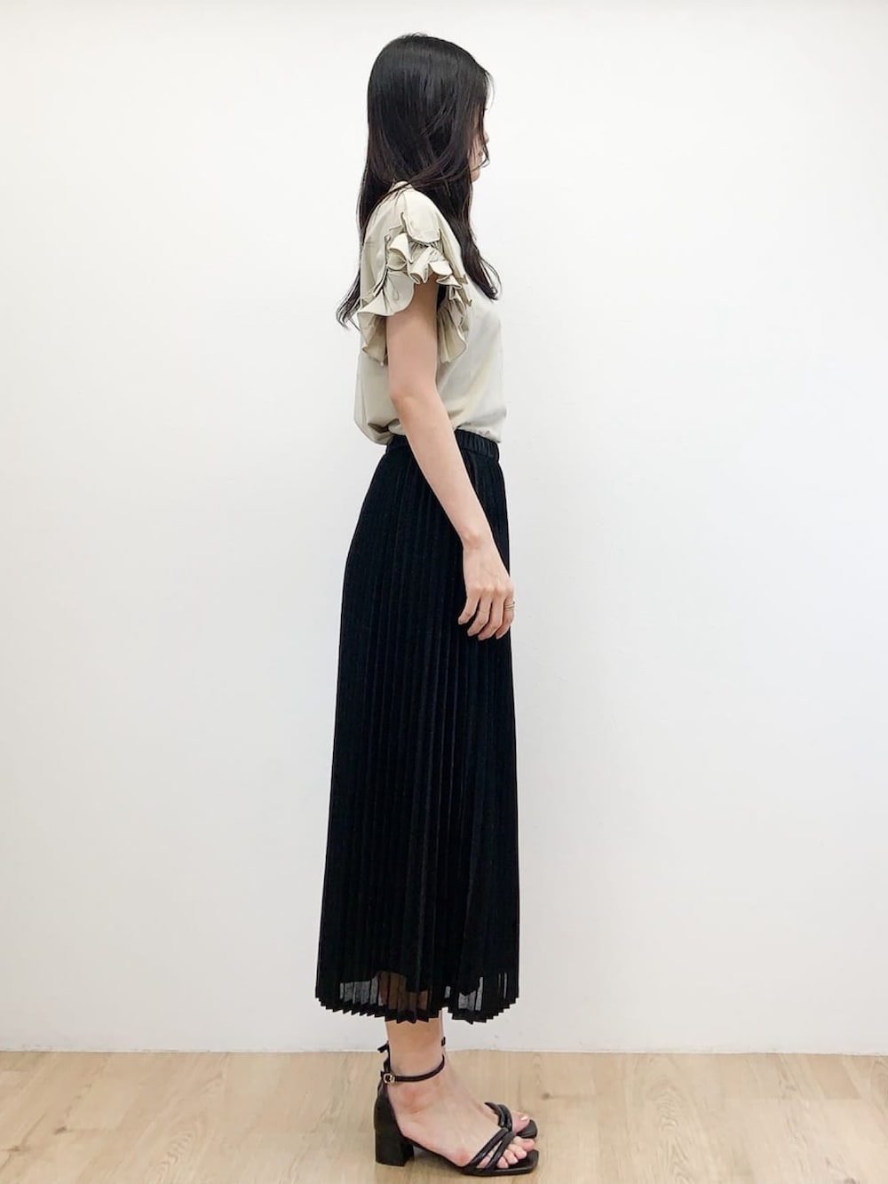 ベージュ系のTシャツ/カットソー、ブラック系のスカート、ブラック系のサンダルを着用したレディースの夏コーディネートの3枚目の写真