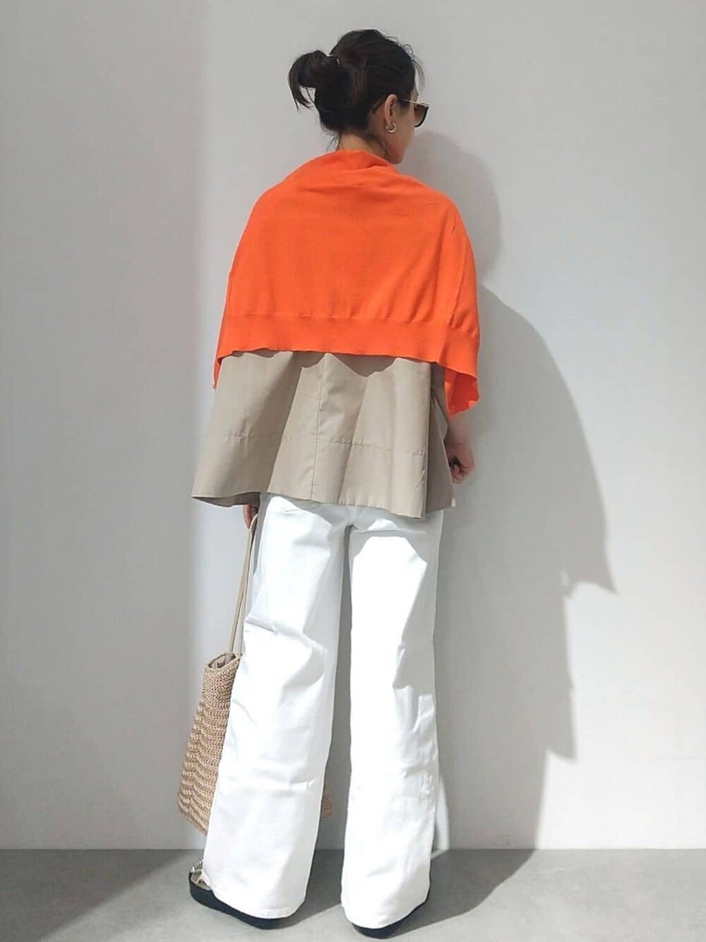 ベージュ系のTシャツ/カットソー、オレンジ系のカーディガン/ボレロ、ホワイト系のデニムパンツを着用したレディースの春コーディネートの3枚目の写真