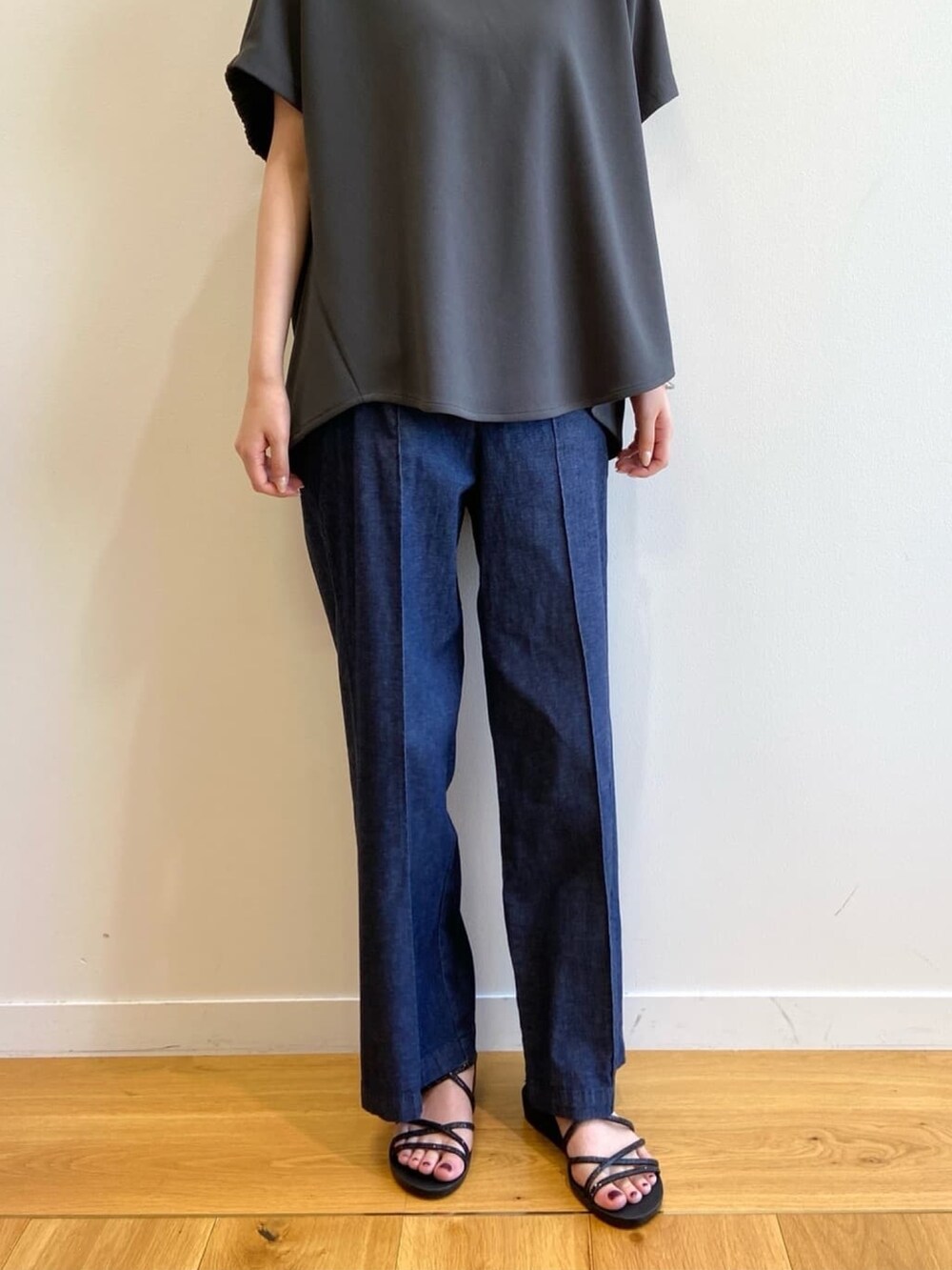 グレー系のTシャツ/カットソー、ブルー系のデニムパンツ、ブラック系のサンダルを着用したレディースの春コーディネートの9枚目の写真