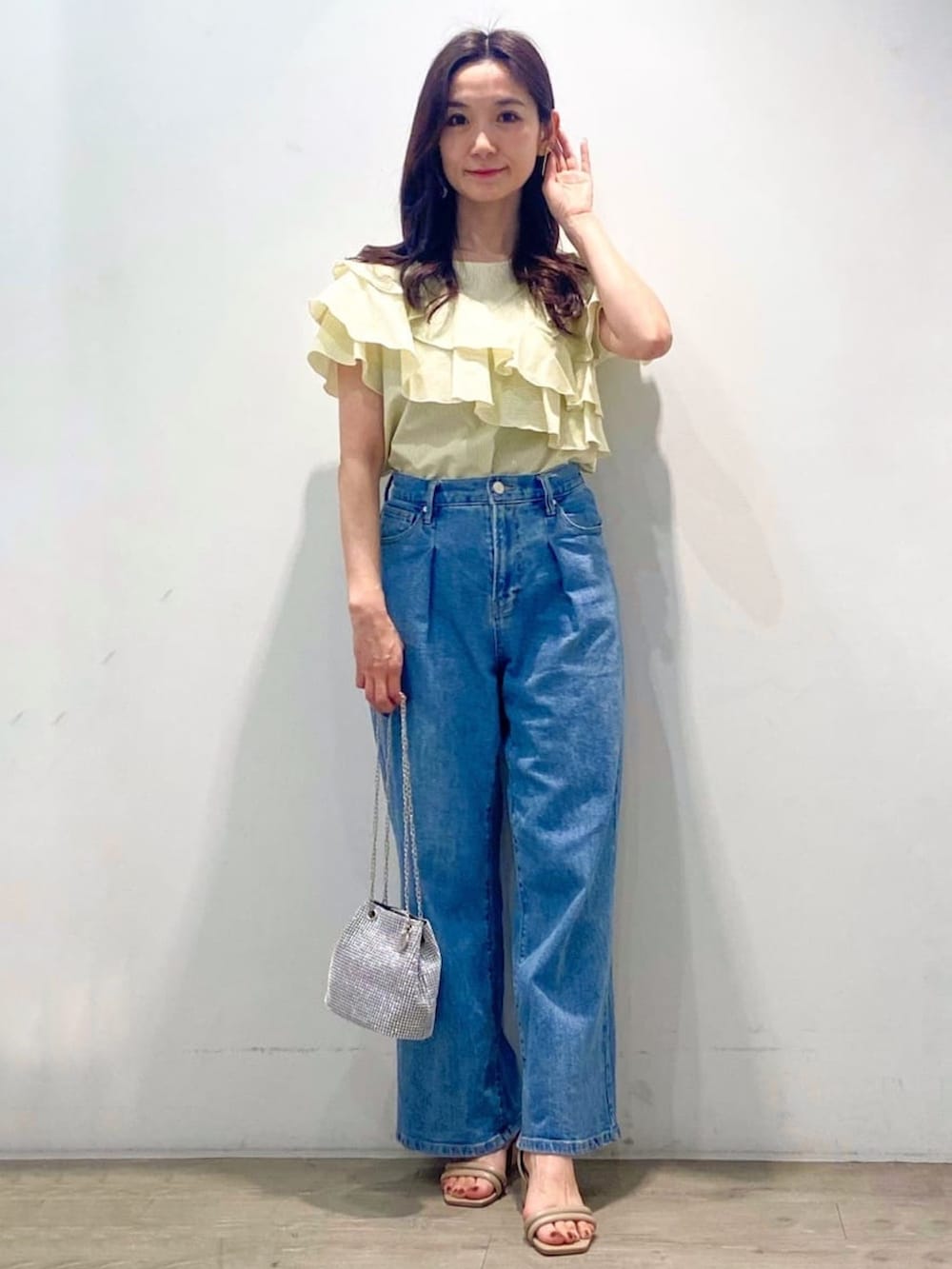 イエロー系のシャツ/ブラウス、ブルー系のデニムパンツ、ホワイト系のショルダーバッグを着用したレディースの春コーディネートの3枚目の写真