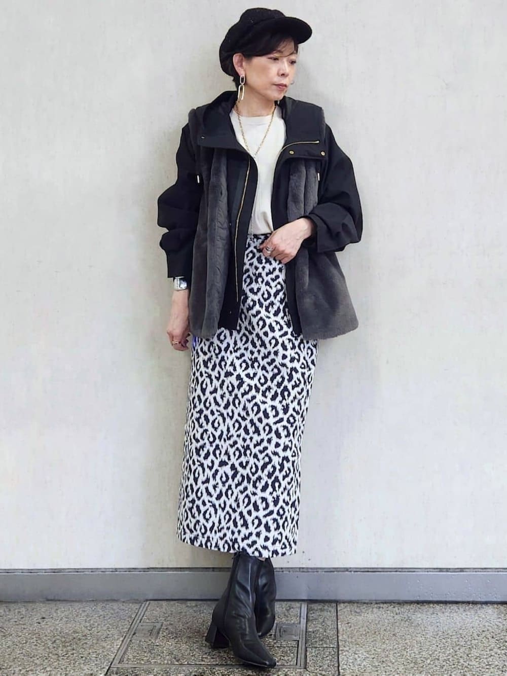 ブラック系のブルゾン、ブルー系のスカート、ブラック系のブーツを着用したレディースの秋コーディネートの2枚目の写真