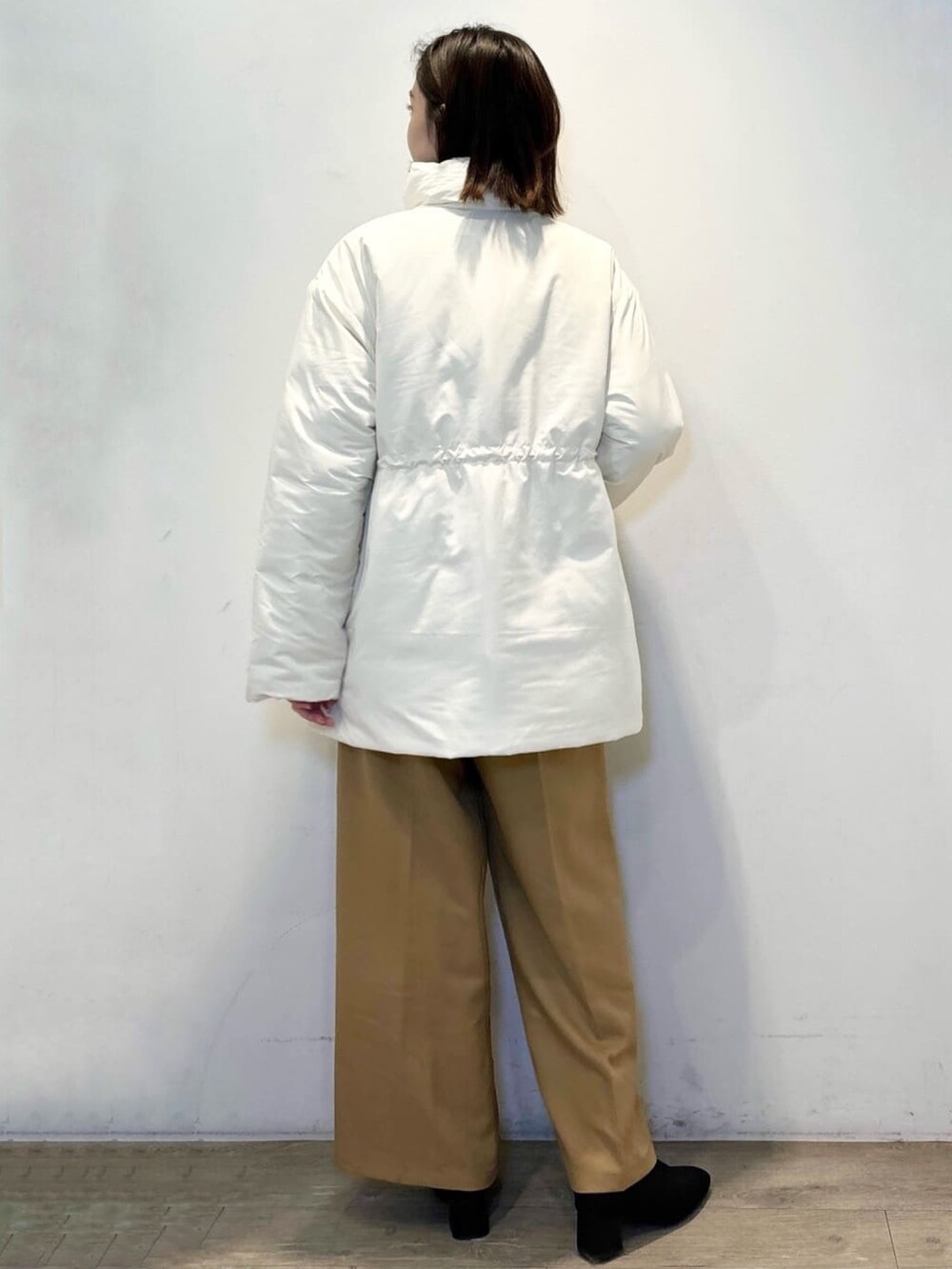 イエロー系のその他パンツ、グレー系のニット/セーター、ホワイト系のその他アウターを着用したレディースの冬コーディネートの3枚目の写真