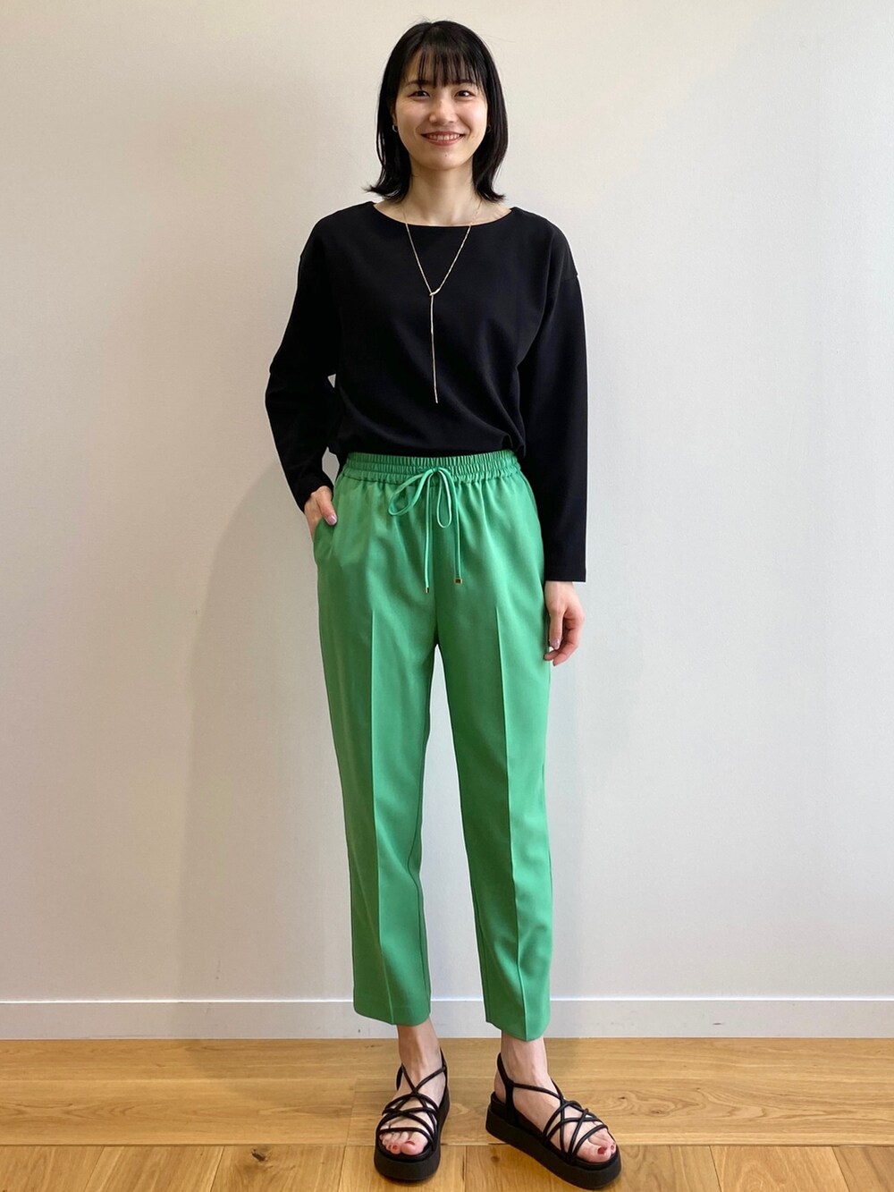 ブラック系のサンダル、グリーン系のその他パンツ、ベージュ系のトレンチコートを着用したレディースの春コーディネートの5枚目の写真