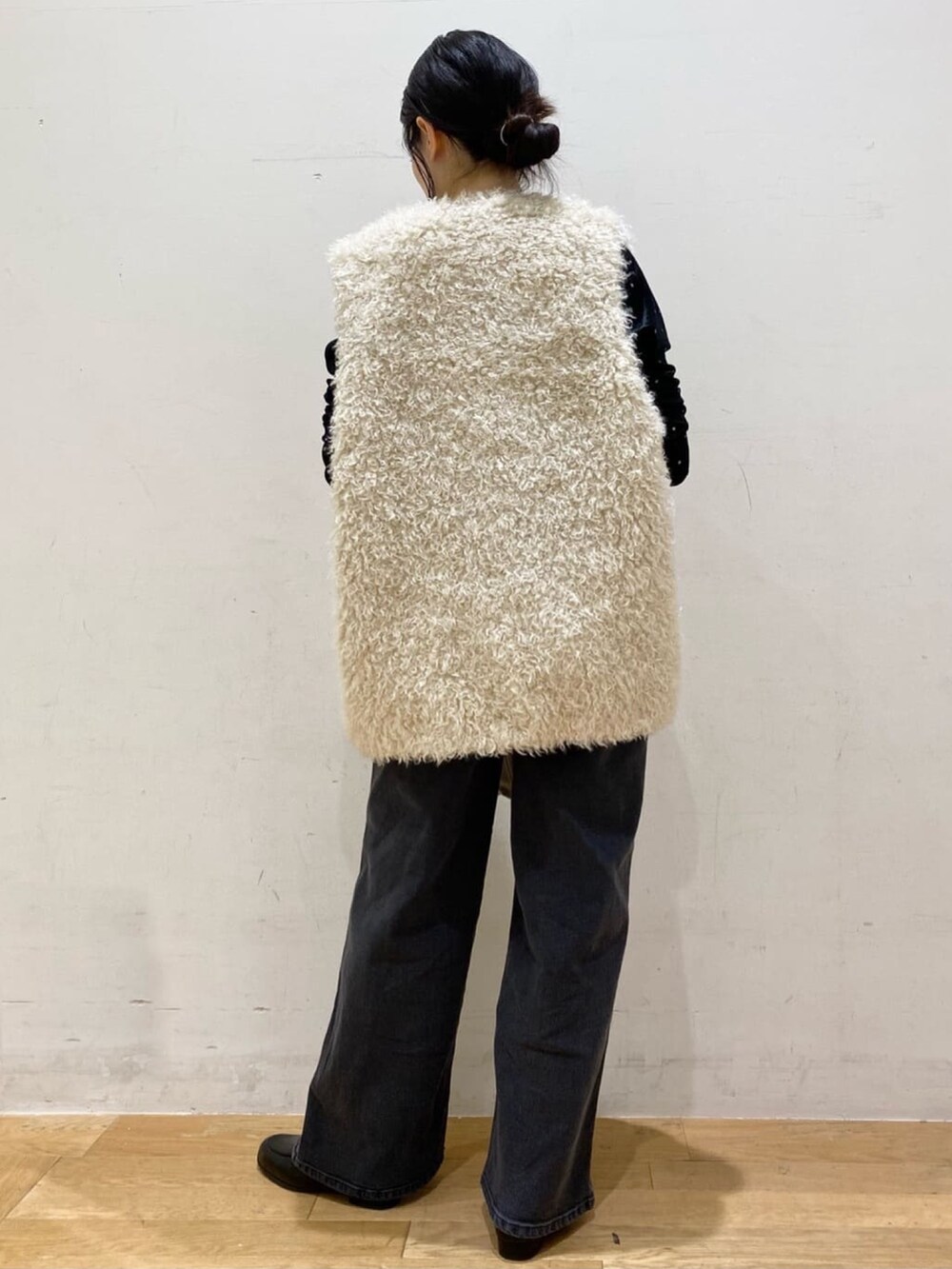 ブラック系のTシャツ/カットソー、ホワイト系のベスト、ホワイト系のショルダーバッグを着用したレディースの秋コーディネートの2枚目の写真