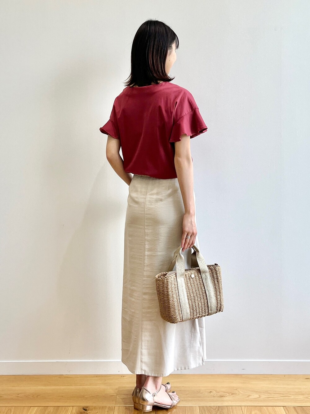 レッド系のTシャツ/カットソー、ゴールド系のサンダル、ベージュ系のスカートを着用したレディースの春コーディネートの3枚目の写真