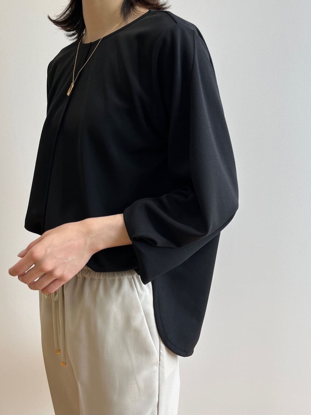 ブラック系のTシャツ/カットソー、ベージュ系のその他パンツ、ブラック系のサンダルを着用したレディースの春コーディネートの5枚目の写真