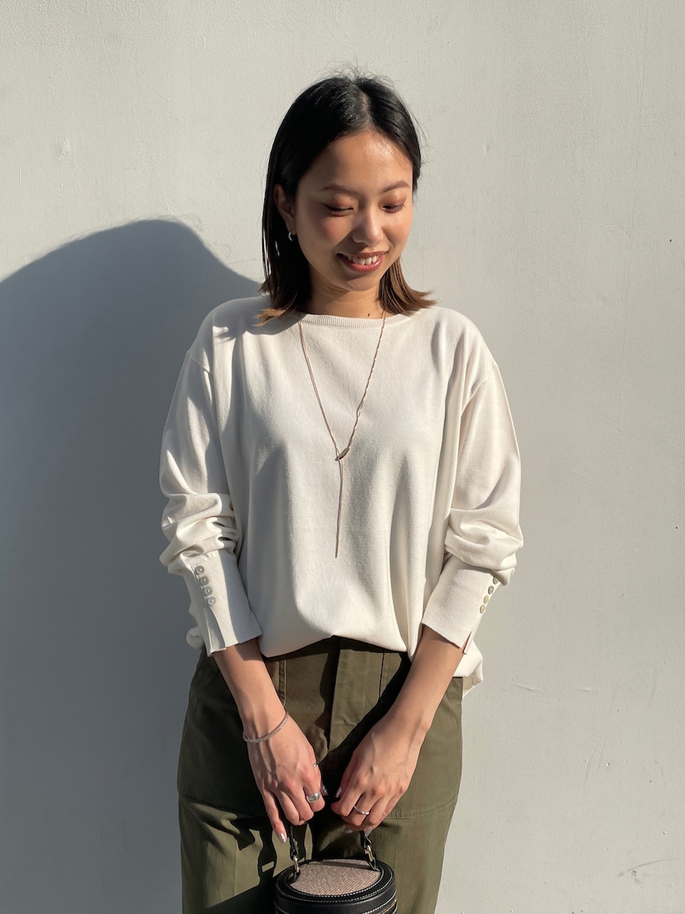 ホワイト系のその他アウター、ホワイト系のニット/セーター、グリーン系のその他パンツを着用したレディースの春コーディネートの5枚目の写真