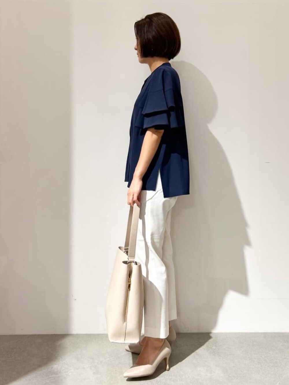 ブルー系のシャツ/ブラウス、ホワイト系のその他パンツ、ベージュ系のショルダーバッグを着用したレディースの夏コーディネートの2枚目の写真