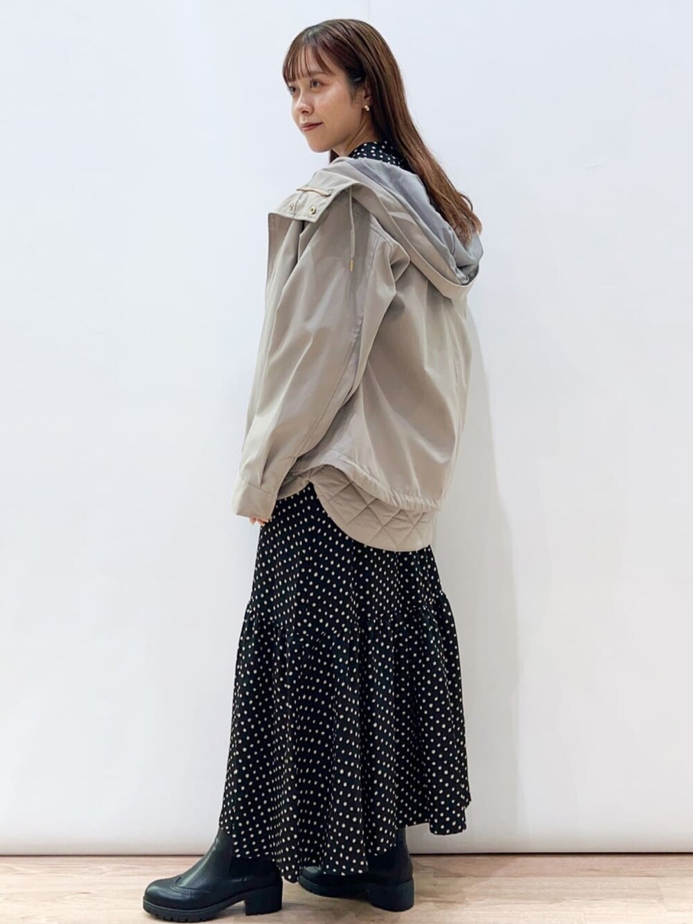 ベージュ系のブルゾン、ブラック系のワンピース、ブラック系のブーツを着用したレディースの秋コーディネートの2枚目の写真