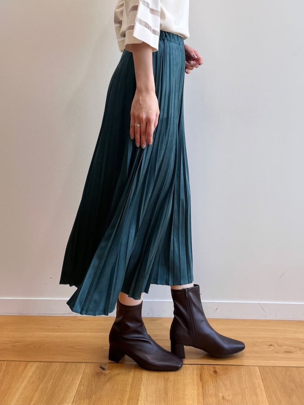 ブラウン系のブーツ、ホワイト系のニット/セーター、ブルー系のスカートを着用したレディースの夏コーディネートの7枚目の写真